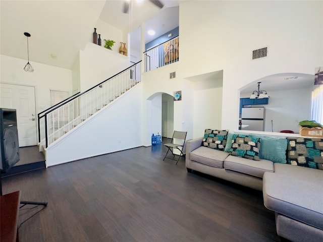 living room featuring a high ceiling and dark hardwood / wood-style flooring