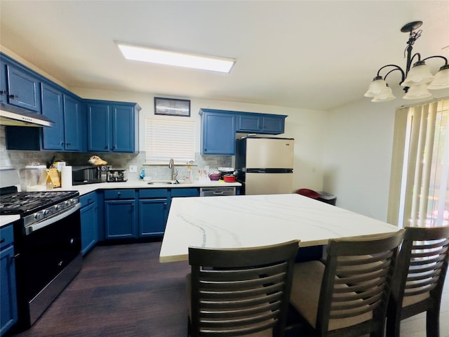 kitchen featuring decorative backsplash, dark hardwood / wood-style flooring, appliances with stainless steel finishes, sink, and a center island