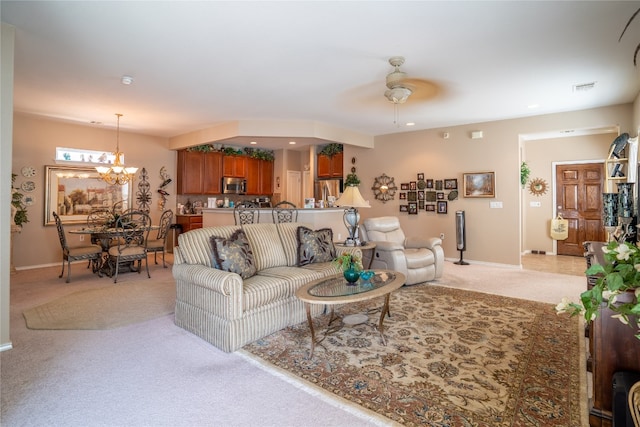 living room featuring carpet floors and ceiling fan with notable chandelier