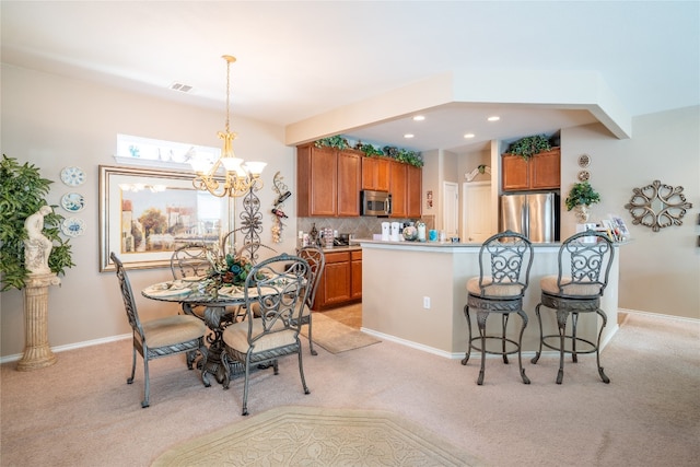 dining room with light carpet and an inviting chandelier