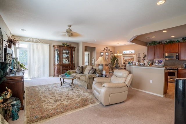 living room with light colored carpet and ceiling fan with notable chandelier