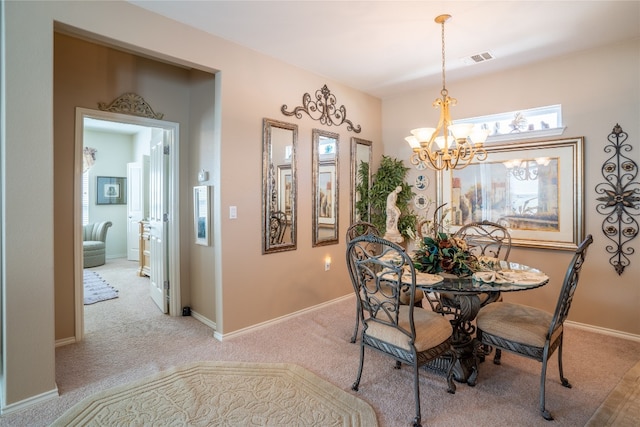 dining space with light carpet and a chandelier