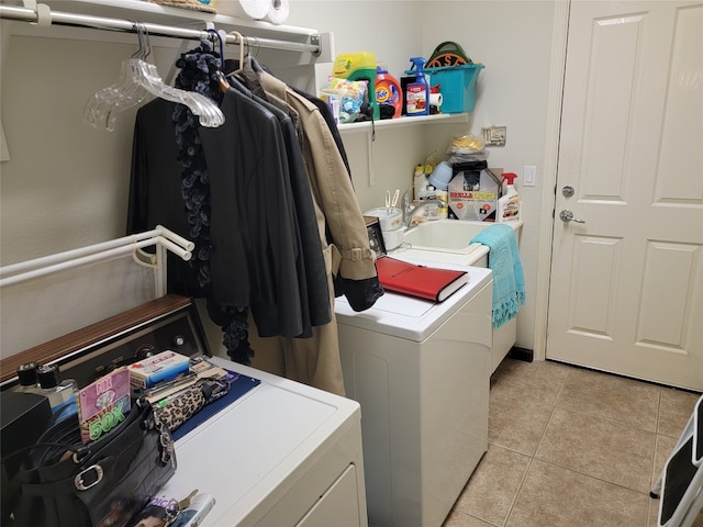 laundry area with washing machine and dryer and light tile patterned floors