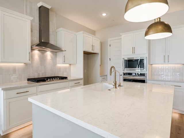 kitchen with white cabinets, sink, wall chimney exhaust hood, and appliances with stainless steel finishes