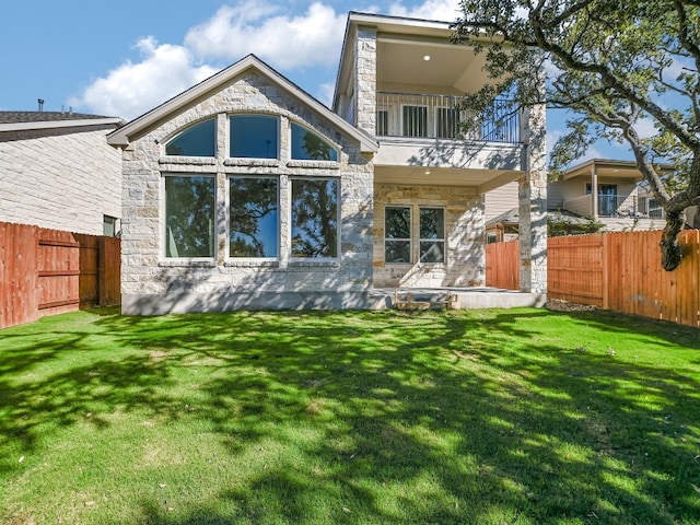 back of property with a balcony and a lawn