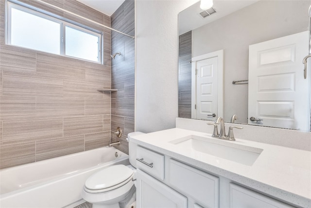 full bathroom with tiled shower / bath combo, vanity, and toilet