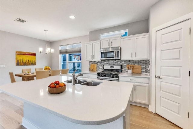 2016 Dinsdale Ln, Austin, TX 78741 - kitchen with appliances with stainless steel finishes, a sink, light wood-style floors, light countertops, and recessed lighting