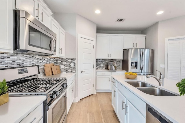 2016 Dinsdale Ln, Austin, TX 78741 - kitchen with appliances with stainless steel finishes, a sink, white cabinetry, light countertops, and recessed lighting