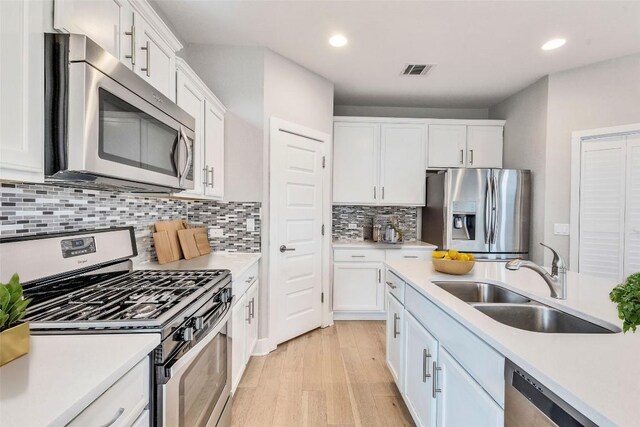 2016 Dinsdale Ln, Austin, TX 78741 - kitchen with appliances with stainless steel finishes, a sink, white cabinetry, light countertops, and recessed lighting