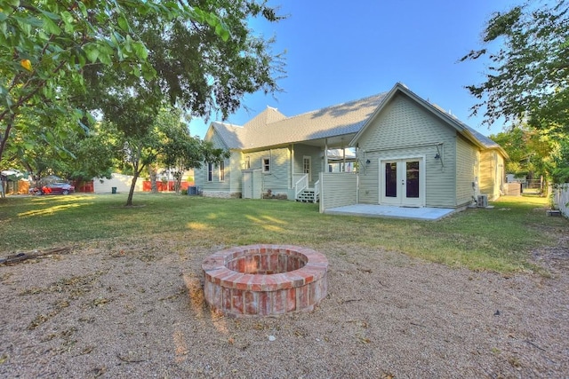 back of property with a patio, fence, a lawn, and french doors