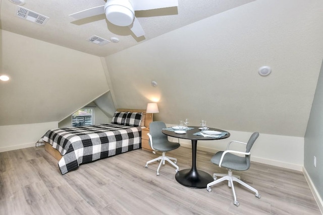 bedroom featuring lofted ceiling, baseboards, visible vents, and wood finished floors