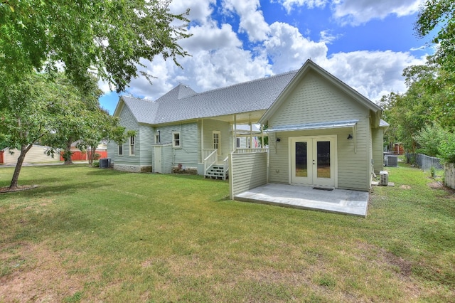 rear view of house featuring french doors, a patio, fence, a yard, and central AC