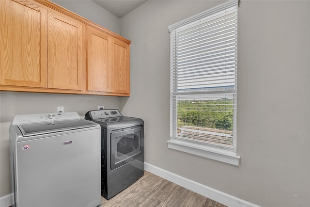 washroom featuring hardwood / wood-style flooring, cabinets, and separate washer and dryer