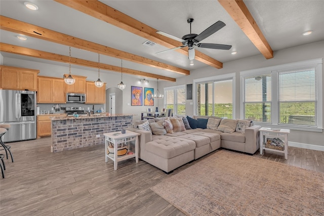 living room featuring ceiling fan, beamed ceiling, and light hardwood / wood-style floors