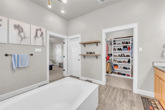 bathroom with vanity, hardwood / wood-style flooring, and a bathing tub