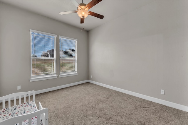 carpeted spare room featuring ceiling fan