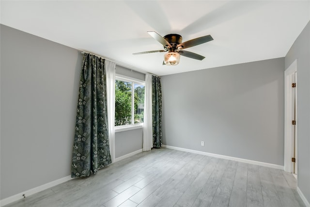 spare room with ceiling fan and light wood-type flooring