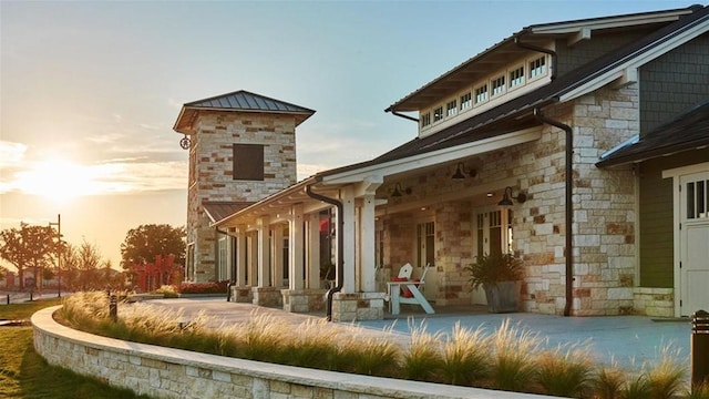 exterior space with stone siding and a patio area