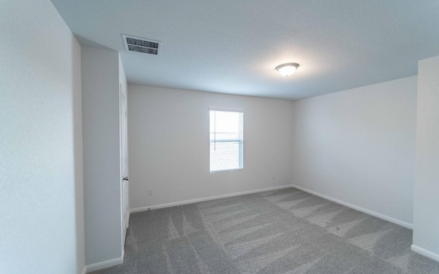 spare room featuring carpet and a textured ceiling