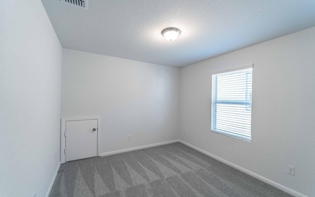 carpeted spare room featuring a textured ceiling