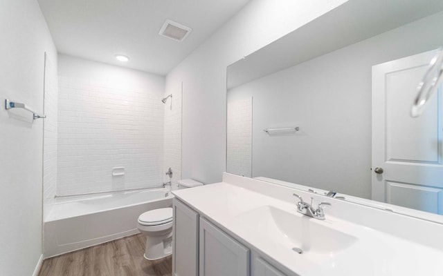 full bathroom featuring hardwood / wood-style flooring, vanity,  shower combination, and toilet