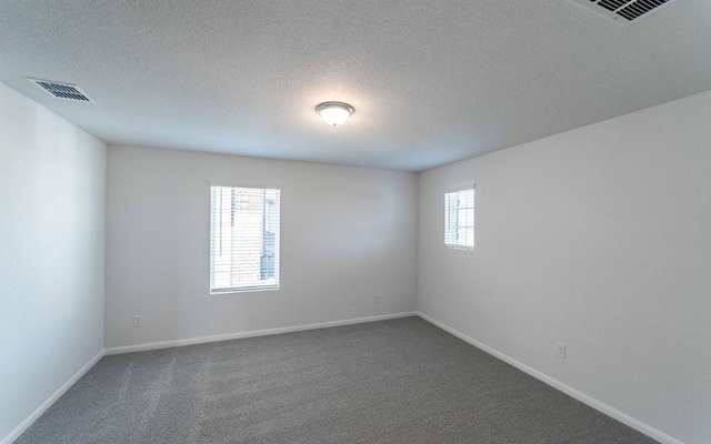 spare room featuring a textured ceiling and carpet floors