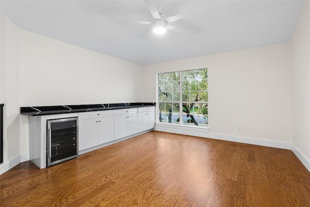 kitchen featuring white cabinets, hardwood / wood-style flooring, wine cooler, and ceiling fan