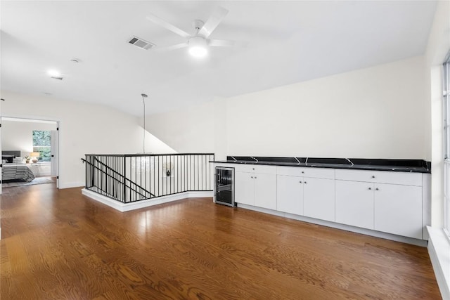 kitchen with dark wood-type flooring, white cabinets, wine cooler, ceiling fan, and decorative light fixtures