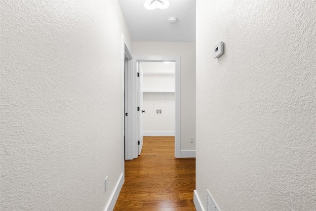 hallway with hardwood / wood-style flooring