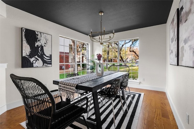 dining space featuring a chandelier, hardwood / wood-style floors, and a textured ceiling