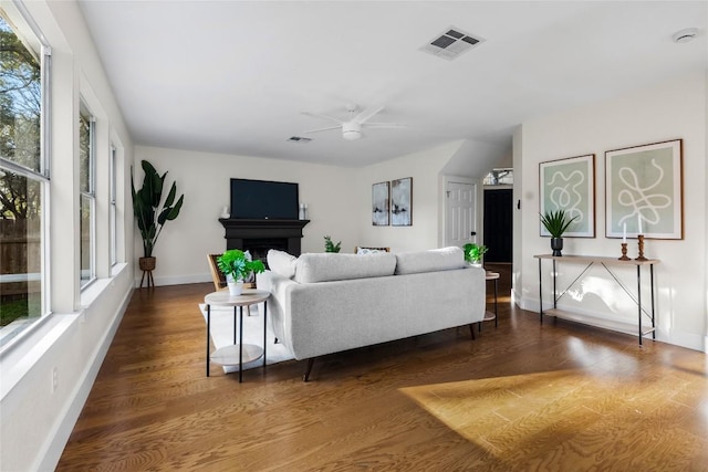 living room with ceiling fan and dark hardwood / wood-style flooring