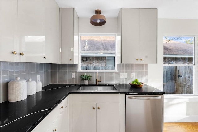 kitchen featuring white cabinetry, dishwasher, sink, light hardwood / wood-style floors, and decorative backsplash