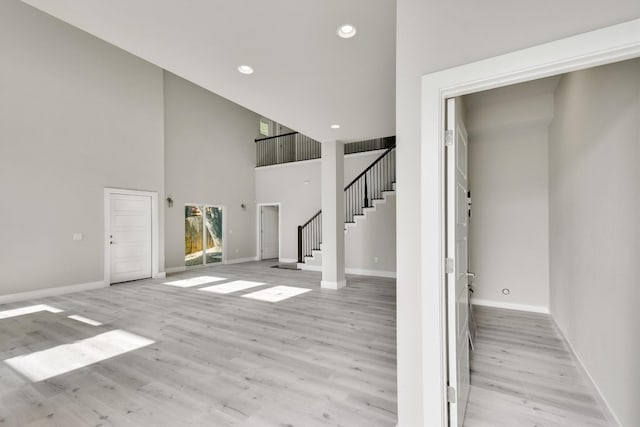 interior space with a high ceiling and light hardwood / wood-style floors