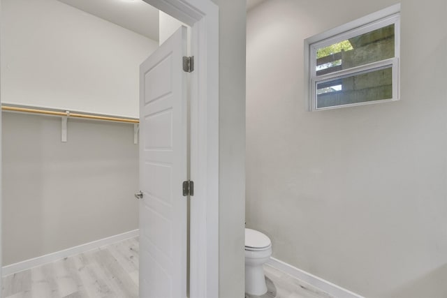 bathroom with toilet and hardwood / wood-style flooring