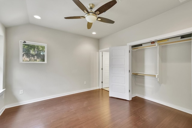 unfurnished bedroom featuring lofted ceiling, dark wood-type flooring, ceiling fan, and a closet