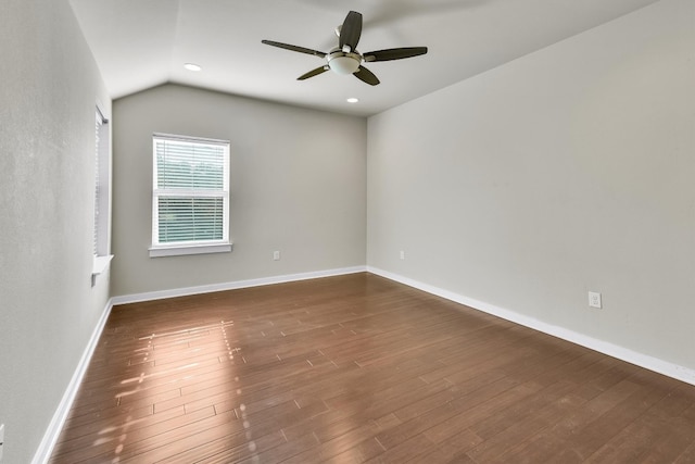 spare room featuring lofted ceiling, ceiling fan, and dark wood-type flooring