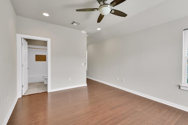 unfurnished bedroom with ensuite bath, hardwood / wood-style flooring, and ceiling fan