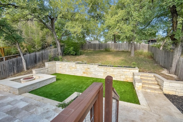 view of yard featuring a patio and an outdoor fire pit