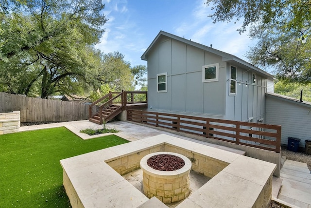 back of property with a yard and a fire pit