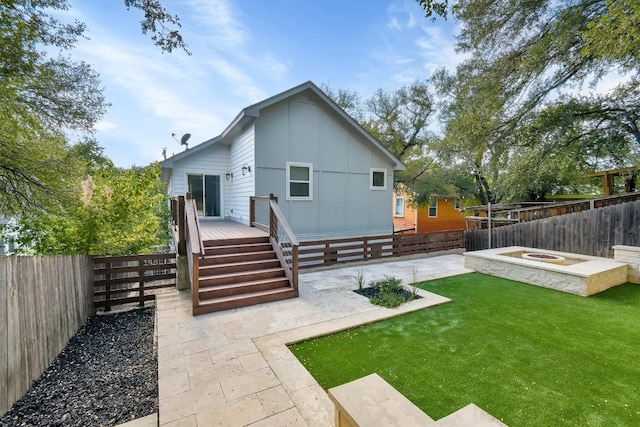 rear view of house featuring a patio area, a yard, and a deck