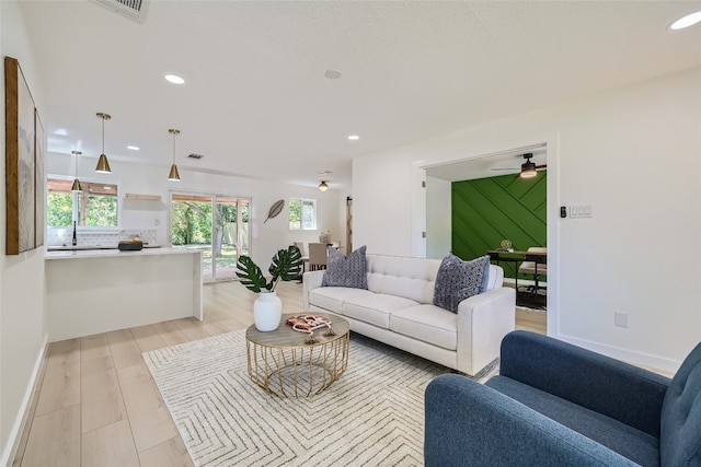 living room featuring ceiling fan and light hardwood / wood-style floors