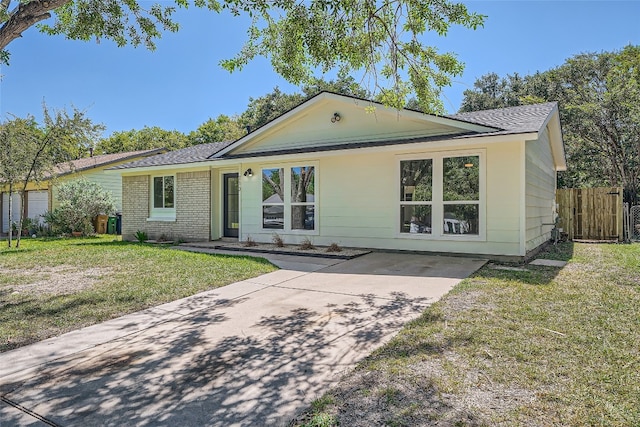 single story home featuring a front lawn and a garage