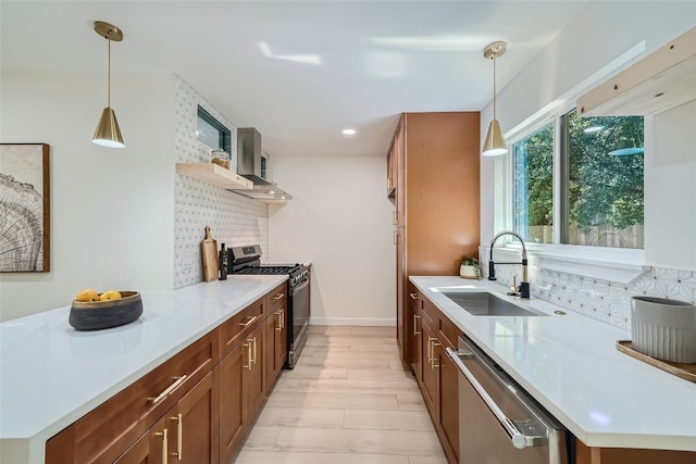 kitchen featuring light wood-type flooring, backsplash, sink, hanging light fixtures, and appliances with stainless steel finishes