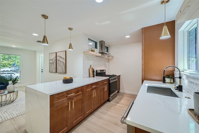 kitchen with pendant lighting, sink, tasteful backsplash, and stainless steel gas range oven