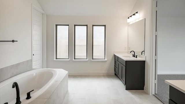 bathroom with vanity, vaulted ceiling, and plenty of natural light