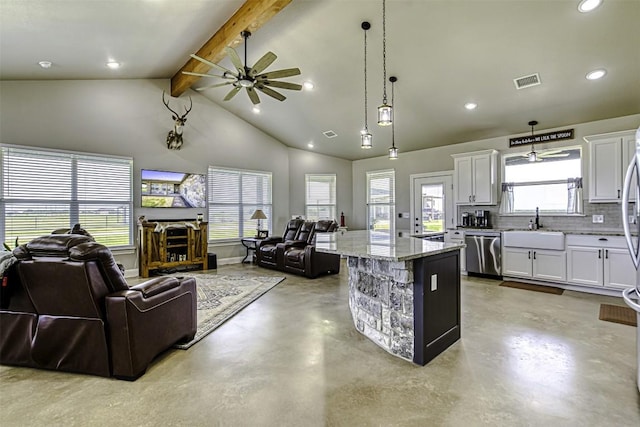 kitchen with pendant lighting, stainless steel dishwasher, a center island, and white cabinets