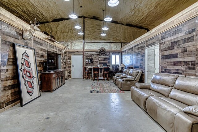 unfurnished living room with high vaulted ceiling and wooden walls