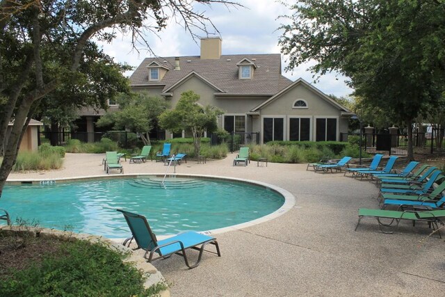 community pool featuring fence and a patio