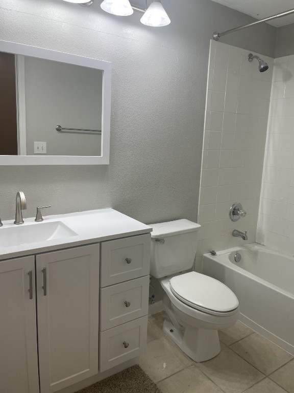 full bathroom with a textured wall, toilet, tile patterned flooring, vanity, and shower / bathing tub combination