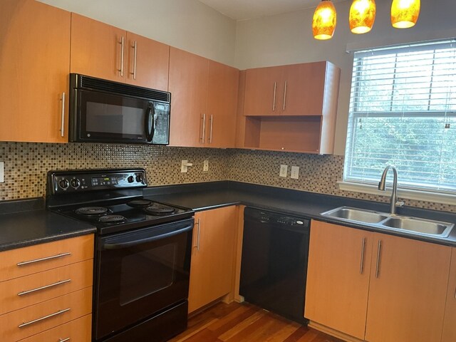 kitchen with decorative light fixtures, sink, dark hardwood / wood-style flooring, decorative backsplash, and black appliances